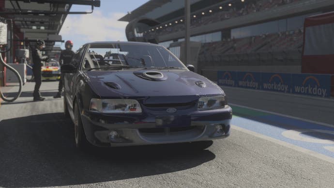 Forza Motorsport screenshot, showing a 1992 Ford Falcon GT, in navy, as it sits in the pits, waiting to race.