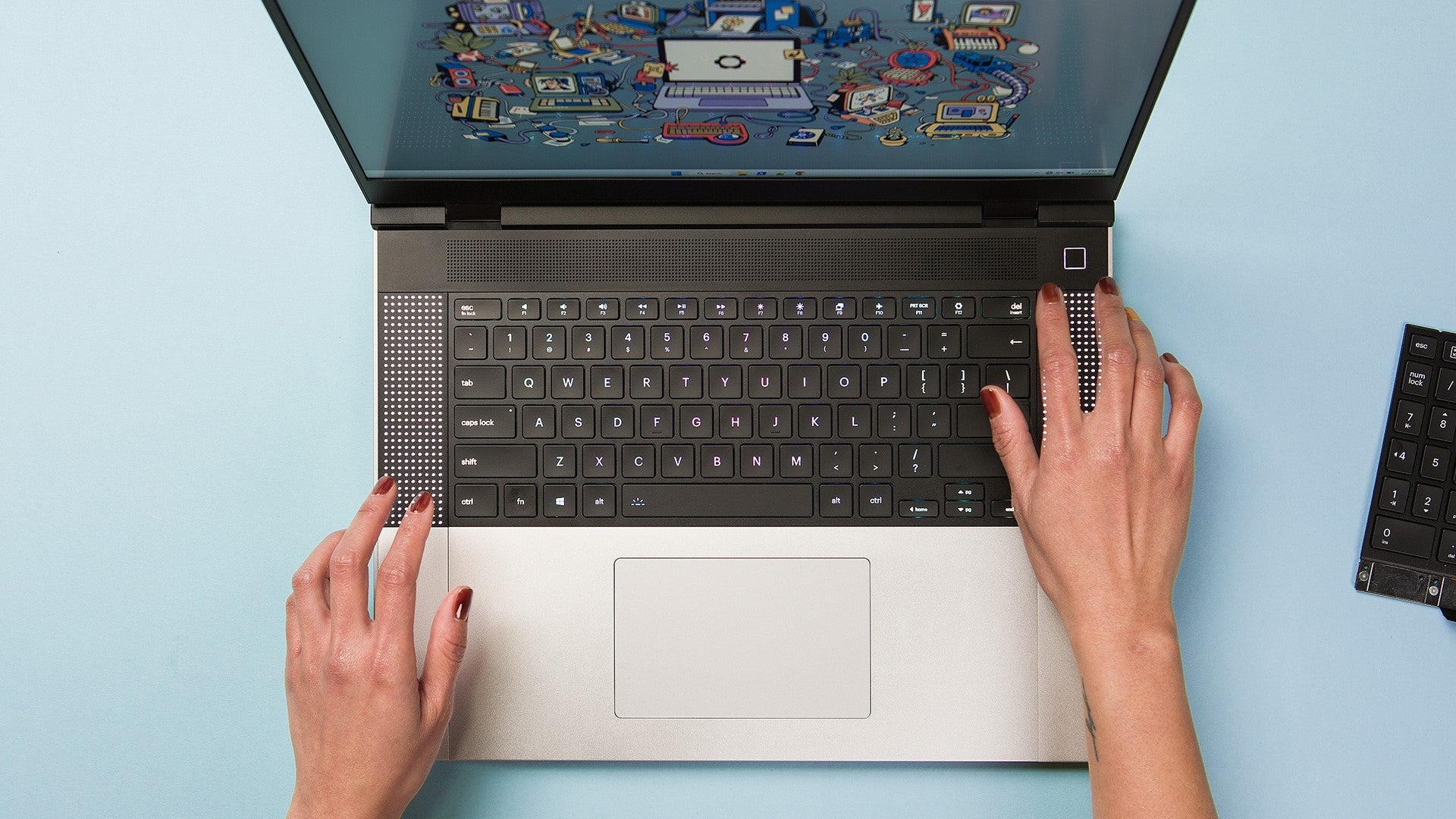 Two hands fondle a Framework Laptop 16 on a blue table.