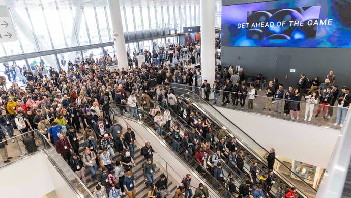 A crowd of people walking down the stairs to the show floor at GDC 2024