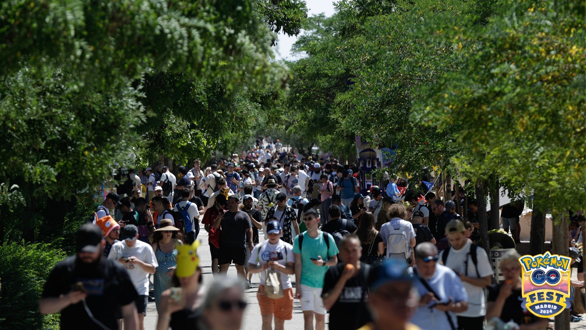 Pok&eacute;mon Go Fest 2024 photo showing crowds of players walking a path in the park.