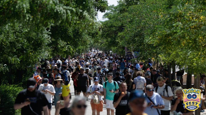 Pokémon Go Fest 2024 photo showing crowds of players walking a path in the park.
