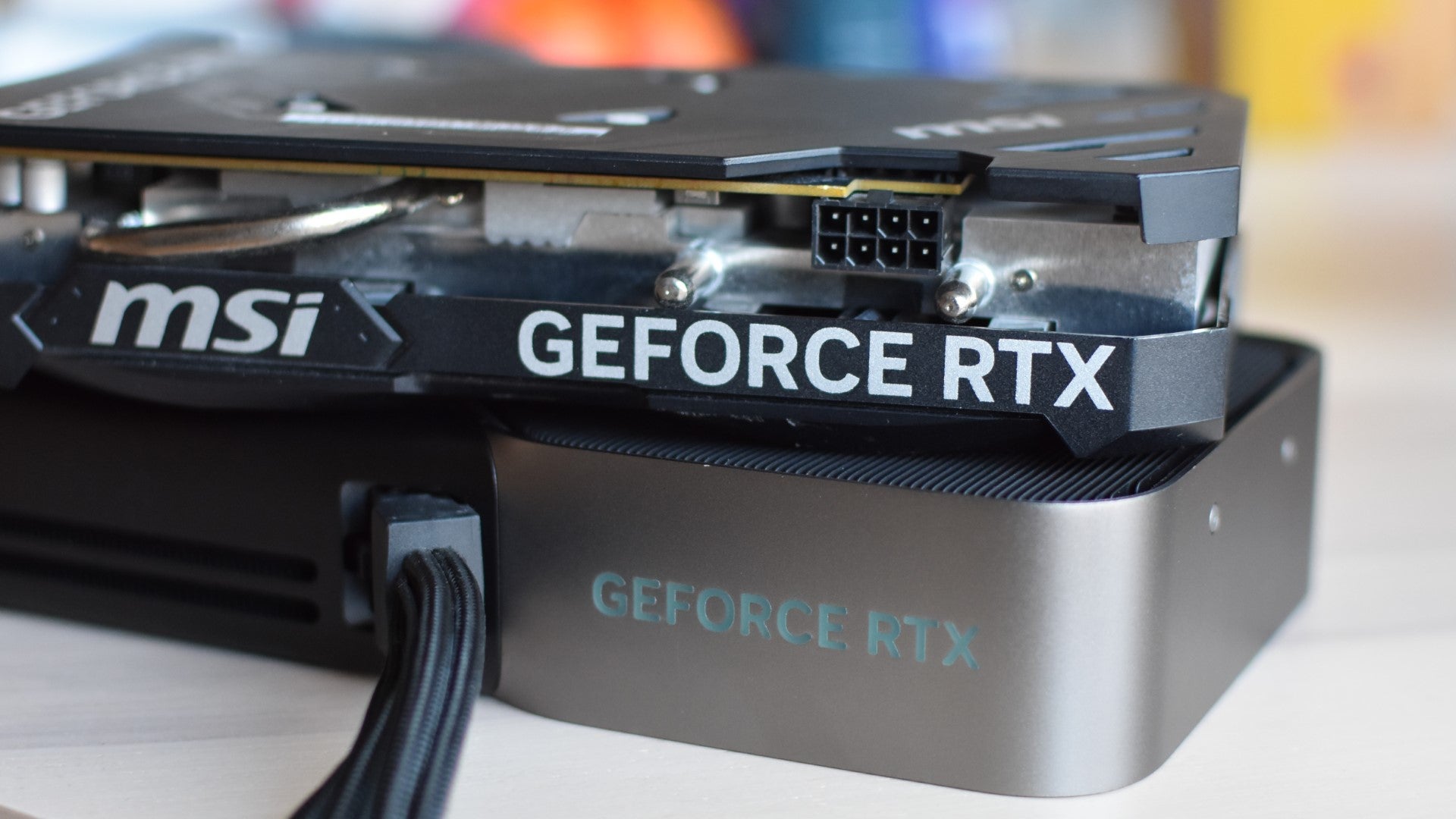 A stack of two GeForce RTX graphics cards on a table. - 1