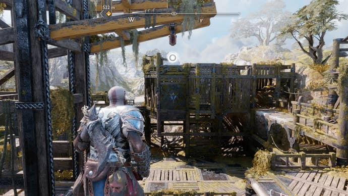 Kratos using his Blades of Chaos to swing across a crane in God of War Ragnarok