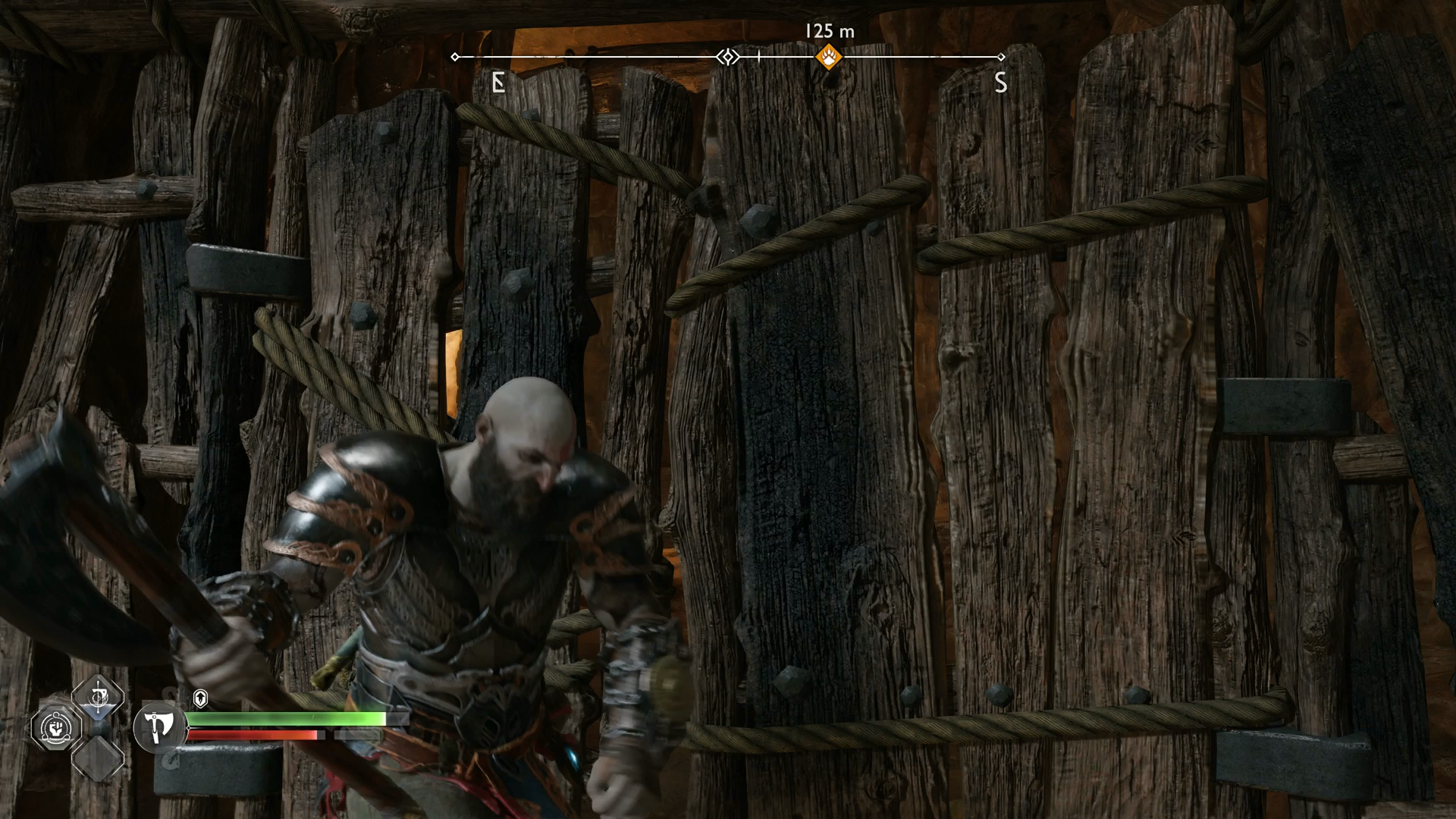 Kratos using his axe to destroy a wooden barrier in The Applecore in God of War Ragnarok