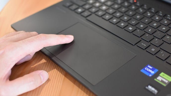 A finger drags over the trackpad on the HP Omen Transcend 16 gaming laptop.