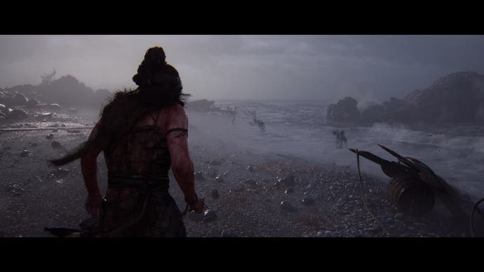 Hellblade 2 screenshot showing Senua on a shoreline with spectral figures cowering in the surf