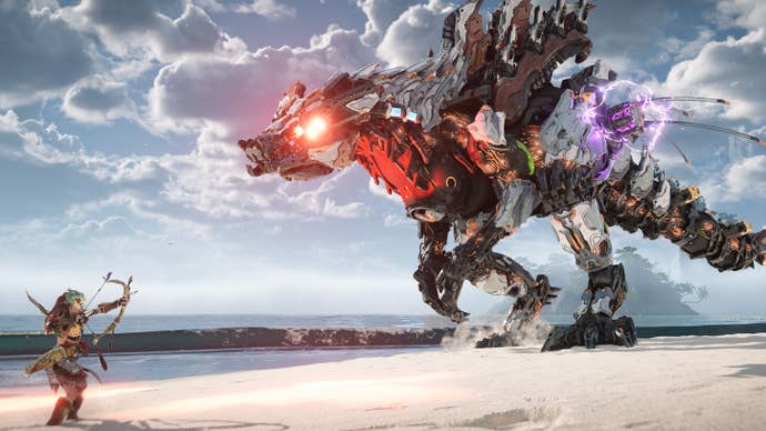 Aloy aims her bow at a massive Slaughterspine Machine on a beach in Horizon Forbidden West: Complete Edition.
