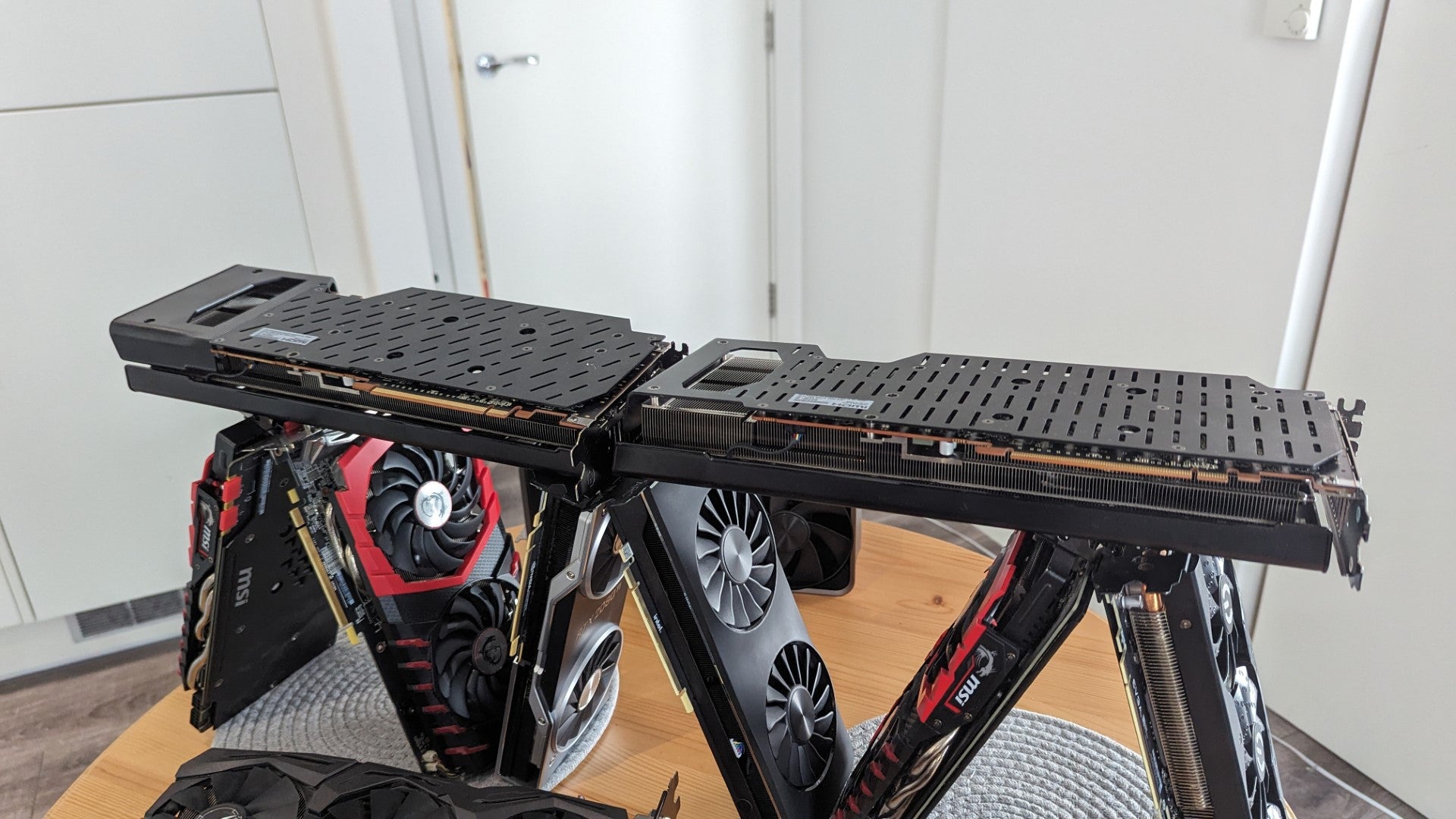 Two long Radeon GPUs form a base above the graphics card house&rsquo;s bottom tier, making it almost sort of look like a house of cards and not just an inefficient stacking method.