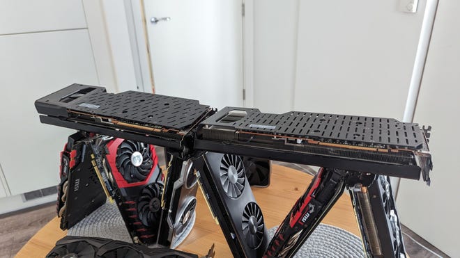 Two long Radeon GPUs form a base above the graphics card house's bottom tier, making it almost sort of look like a house of cards and not just an inefficient stacking method.