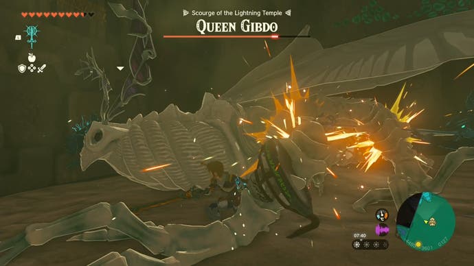 Link attacking the collapsed Queen Gibdo boss with a melee weapon while she's down.