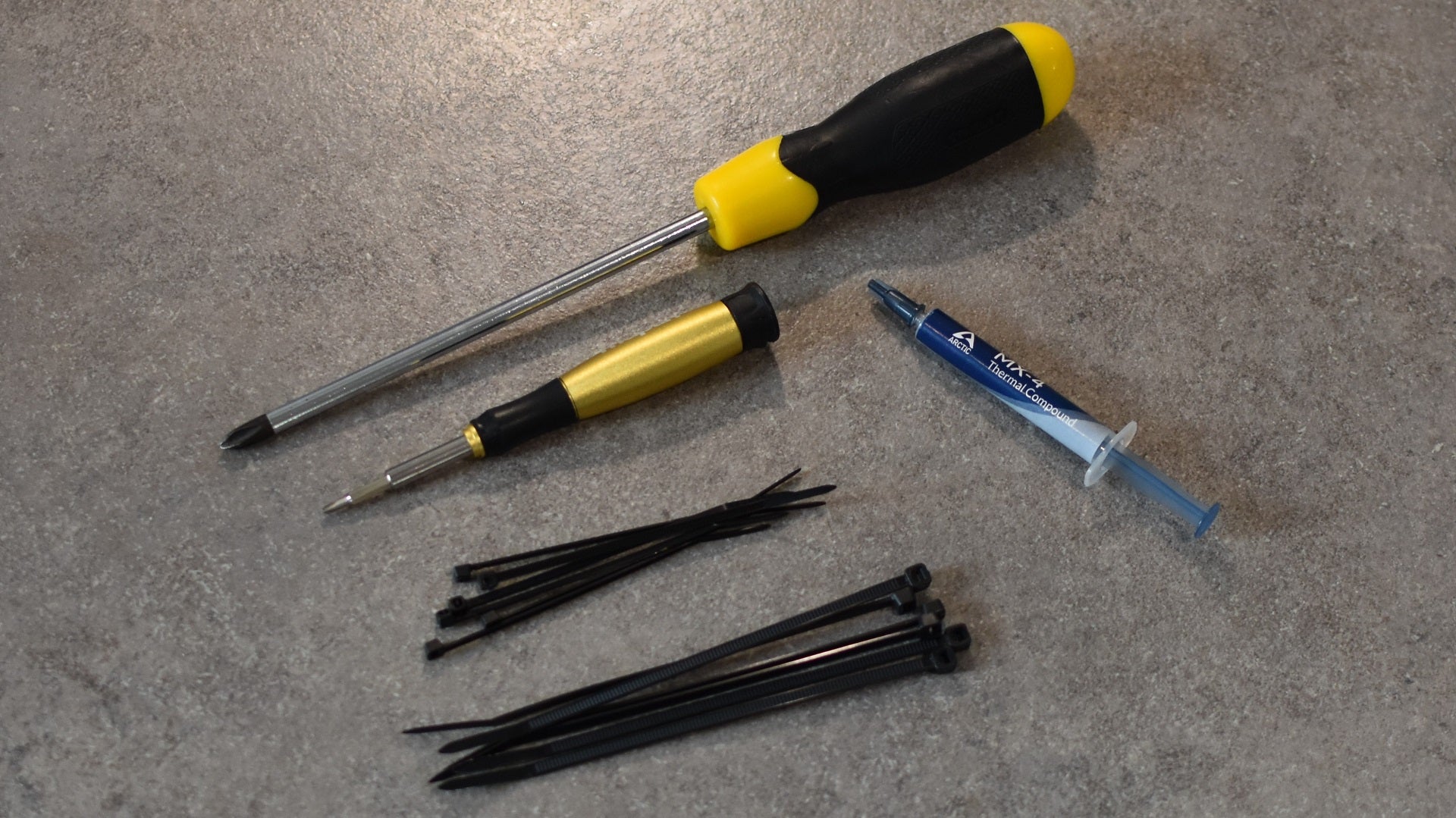 The tools you&rsquo;ll need to build a PC: crosshead screwdrivers, thermal paste, and cable ties.