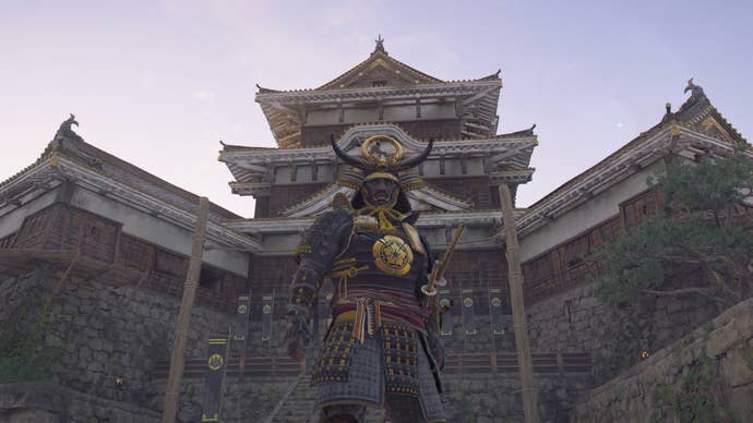 Yasuke standing below the highest tower of Yamazaki Castle in Assassin’s Creed Shadows.