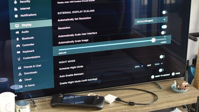 Step 4 of how to connect a Steam Deck to a TV with an adapter: in the Steam Deck's Display settings menu, uncheck "Automatically scale image" and adjust the slider until the picture fits your screen.