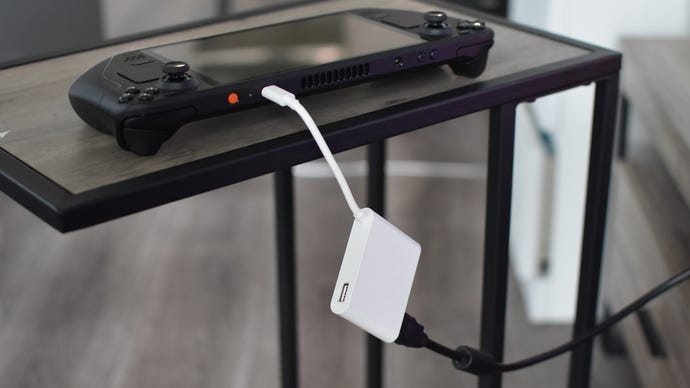 A Steam Deck connected to a TV via a USB-C-to-HDMI adapter and HDMI cable.