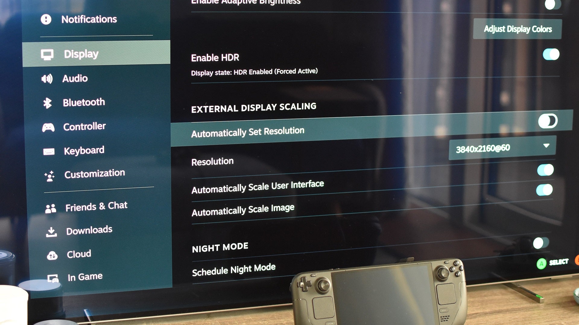 Step 3 of how to connect a Steam Deck to a TV with a docking station: Enter the Steam Deck's Display settings, uncheck 'Automatically set resolution', and select your TV's resolution. - 12
