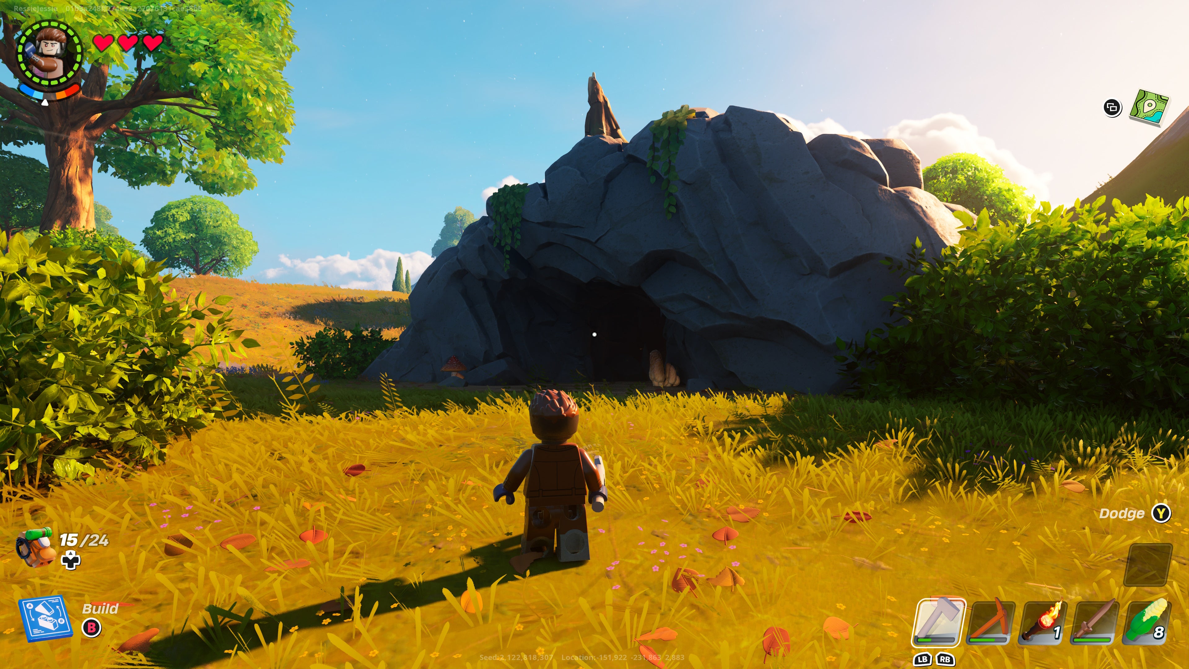 a lego character standing in front of a cave in a grassy area