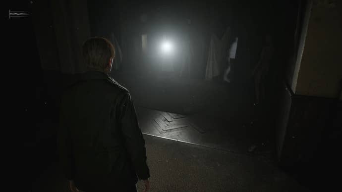 James looking at the bright light of the Flashlight on a mannequin doll inside a dark room in Silent Hill 2.