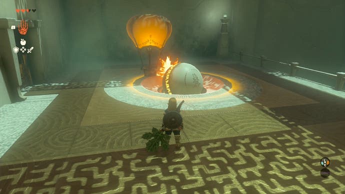 Link detaching a large metal ball from a hot air balloon and moving it into a gap in the floor in the Sinakawak Shrine.