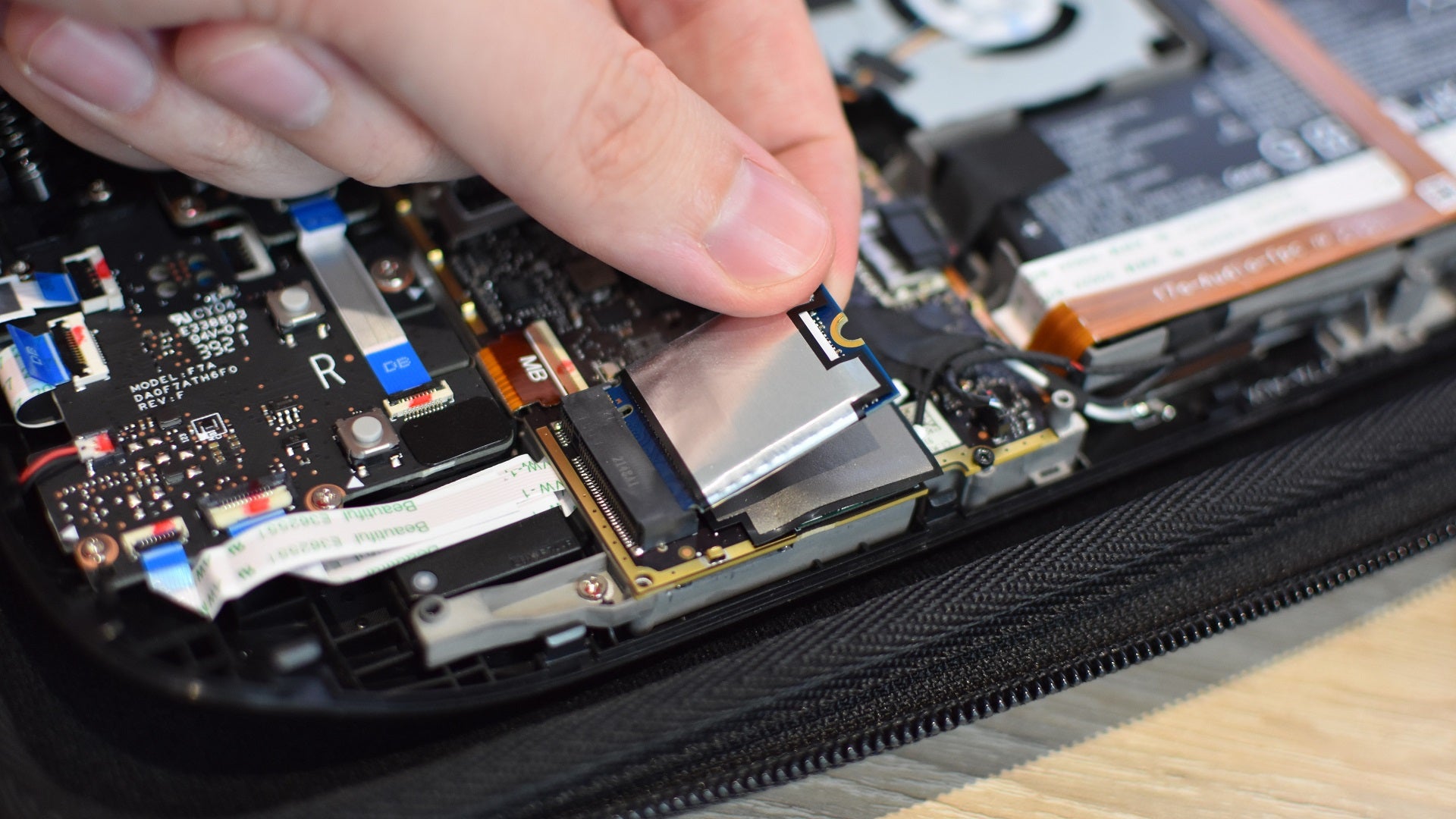 Step 6 of how to install an SSD in a Steam Deck: Remove the screw holding the SSD in place and gently pull it out opf the M.2 slot. - 12