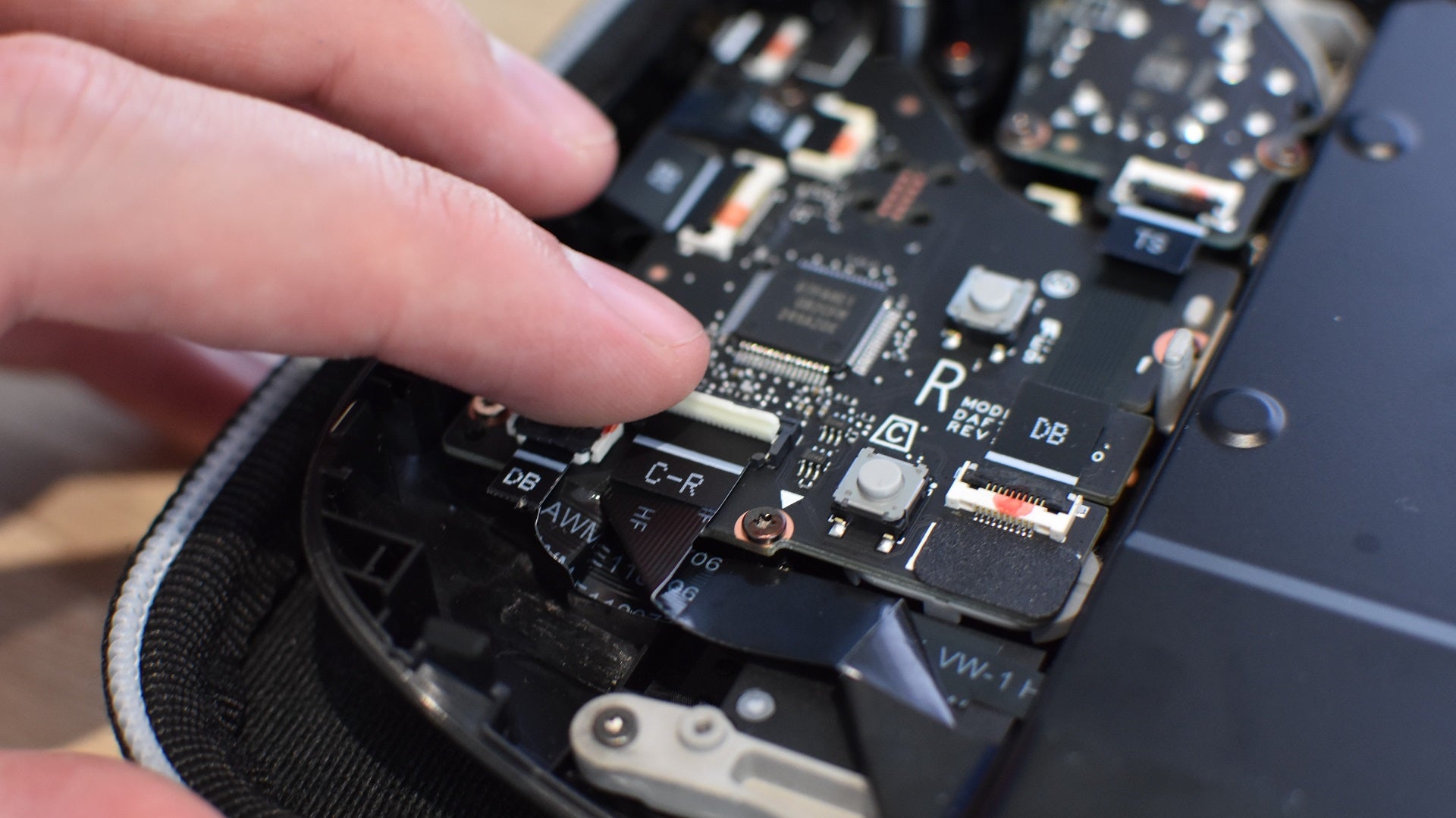 Step 9 of how to install an SSD in a Steam Deck: On a Steam Deck OLED, reconnect the battery connectot, then reattach the ribbon cable. Then, screw the metal plate back into place. - 16
