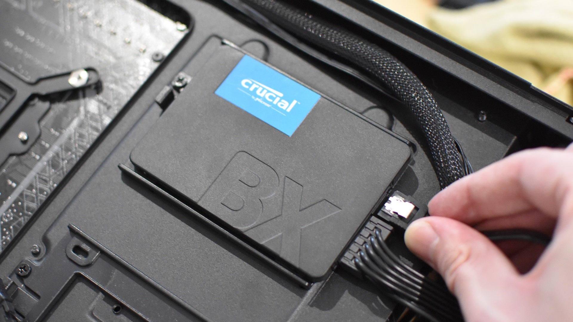 Step 3 of how to install a SATA SSD: Replace the mounting hardware on the case and attach SATA power and data cables.