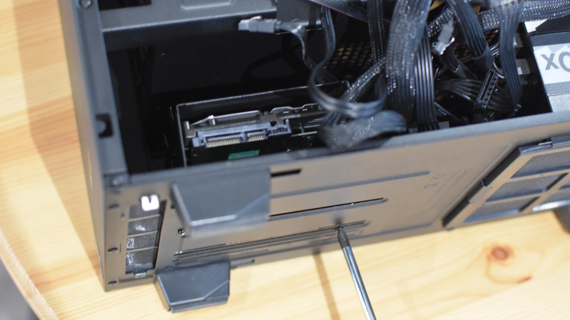 Step 3 of how to install an internal HDD: Replace the drive cage, now containing the hard drive, to its original spot in the PC case.