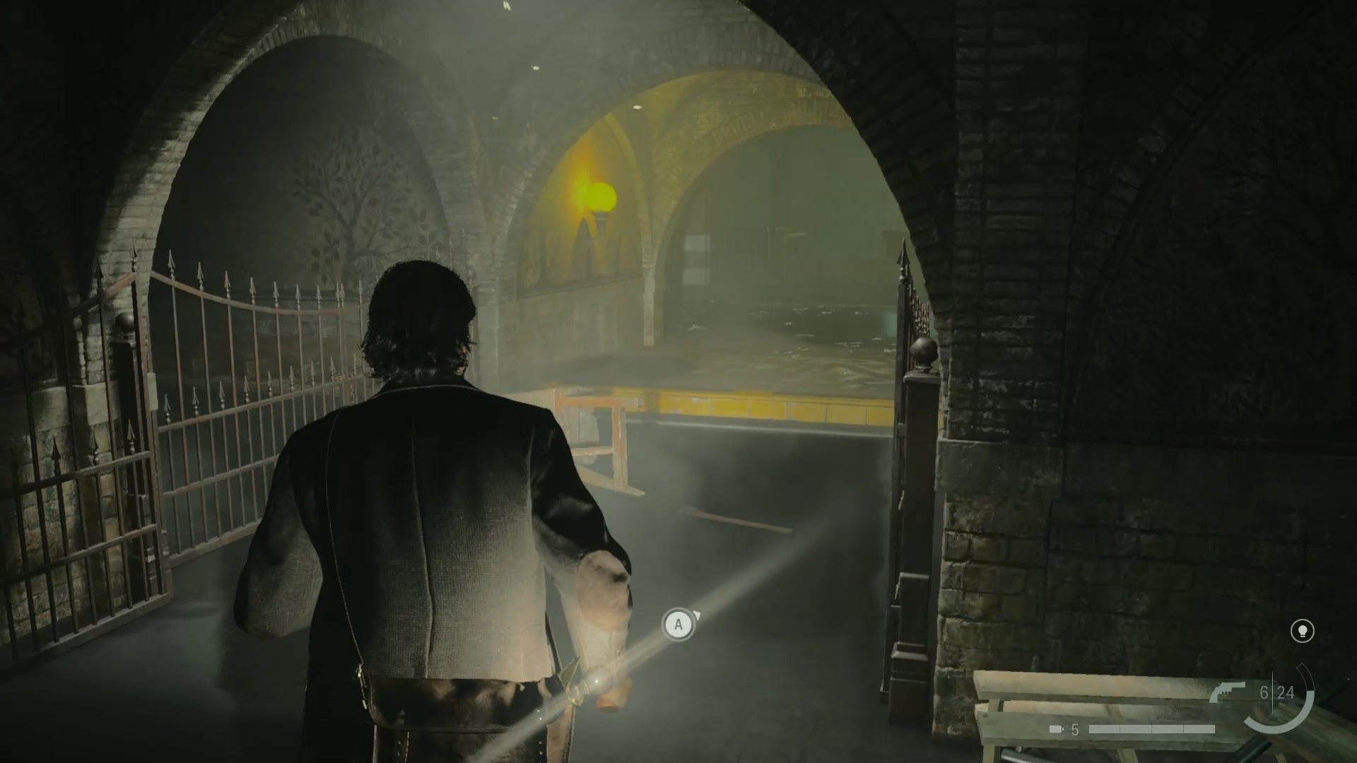 alan standing in shallow water in front of a small ledge with a yellow top, in a dark rundown train station tunnel