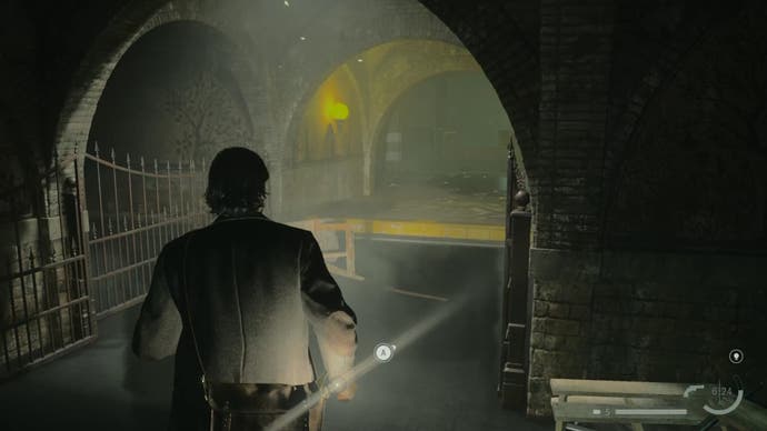 alan standing in shallow water in front of a small ledge with a yellow top, in a dark rundown train station tunnel