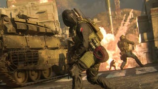 a soldier in a black gas mask looking off to the right while an explosion is behind him and a tank is to his left