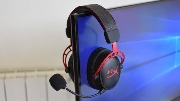 The HyperX Cloud Alpha Wireless headset resting on the corner of a monitor.