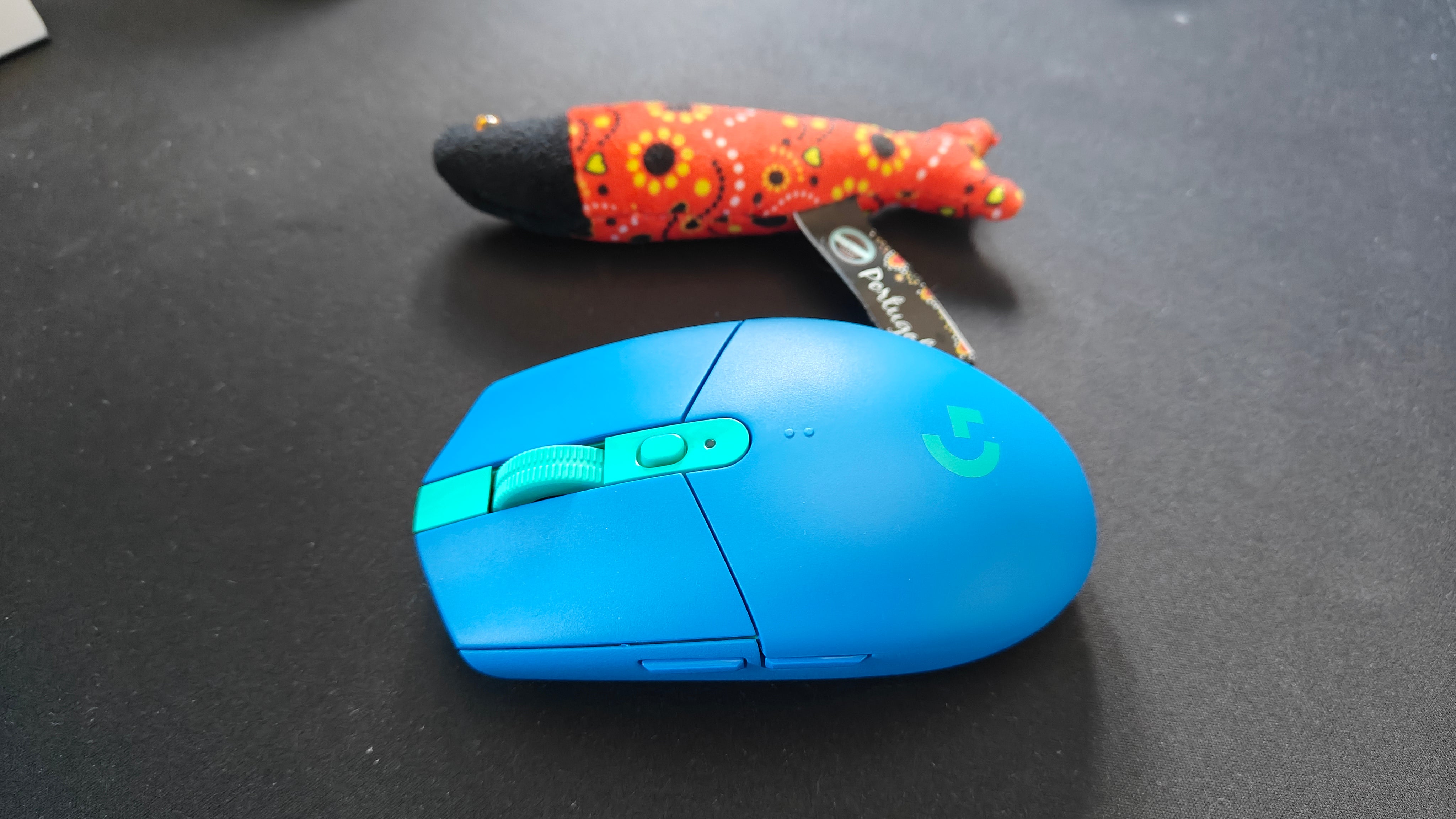 logitech g305 wireless in blue with a portugese fish for scale