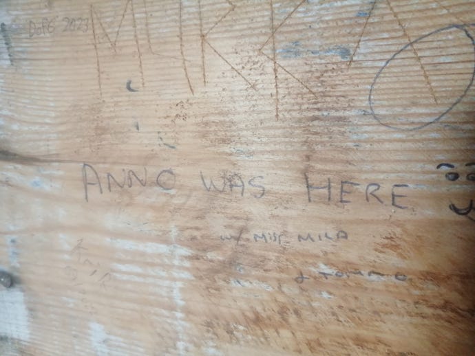 The message "Anno was here" scribbled on a wooden wall in biro