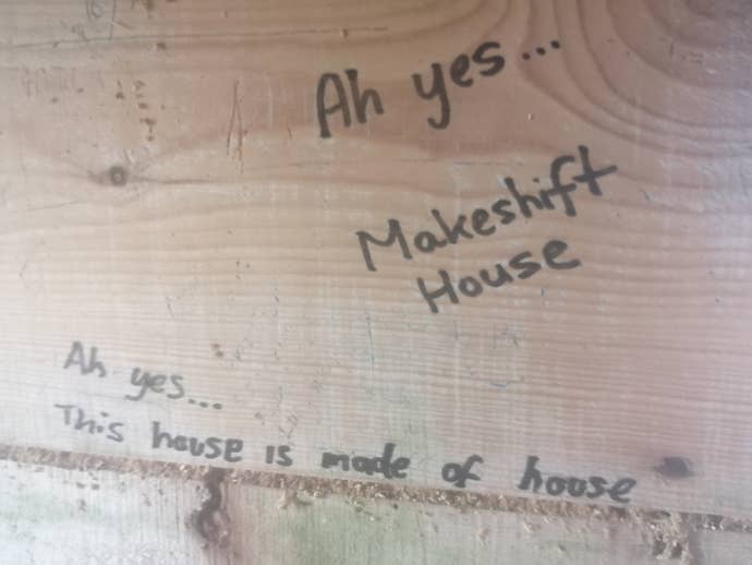 The phrases “Ah yes… makeshift house” and “Ah yes… this house is made of house” written in felt tip on a wooden wall