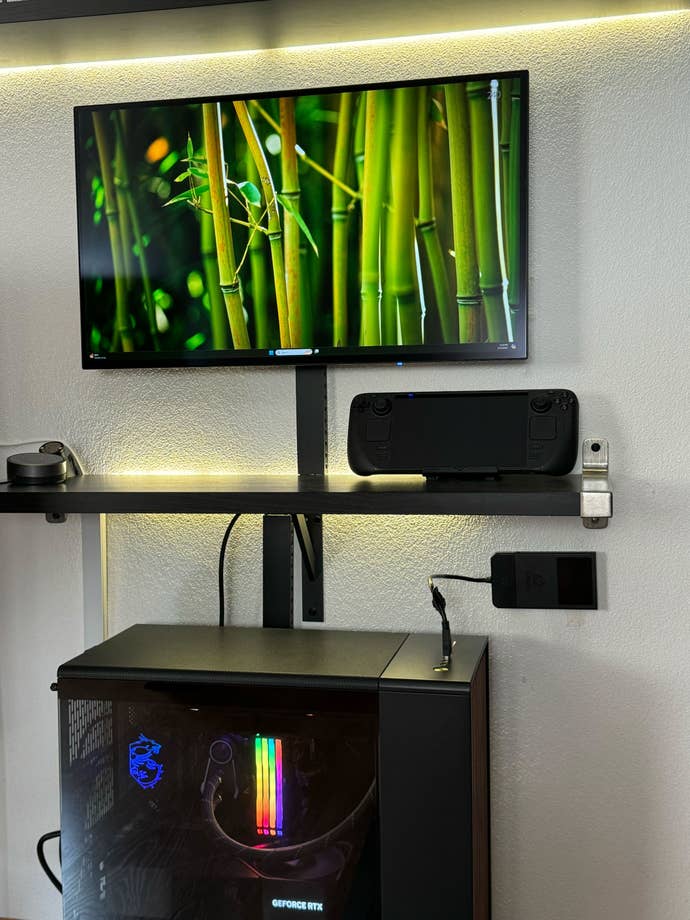 a KTC G27P6 monitor mounted on a wall next to a Steam Deck and above a PC