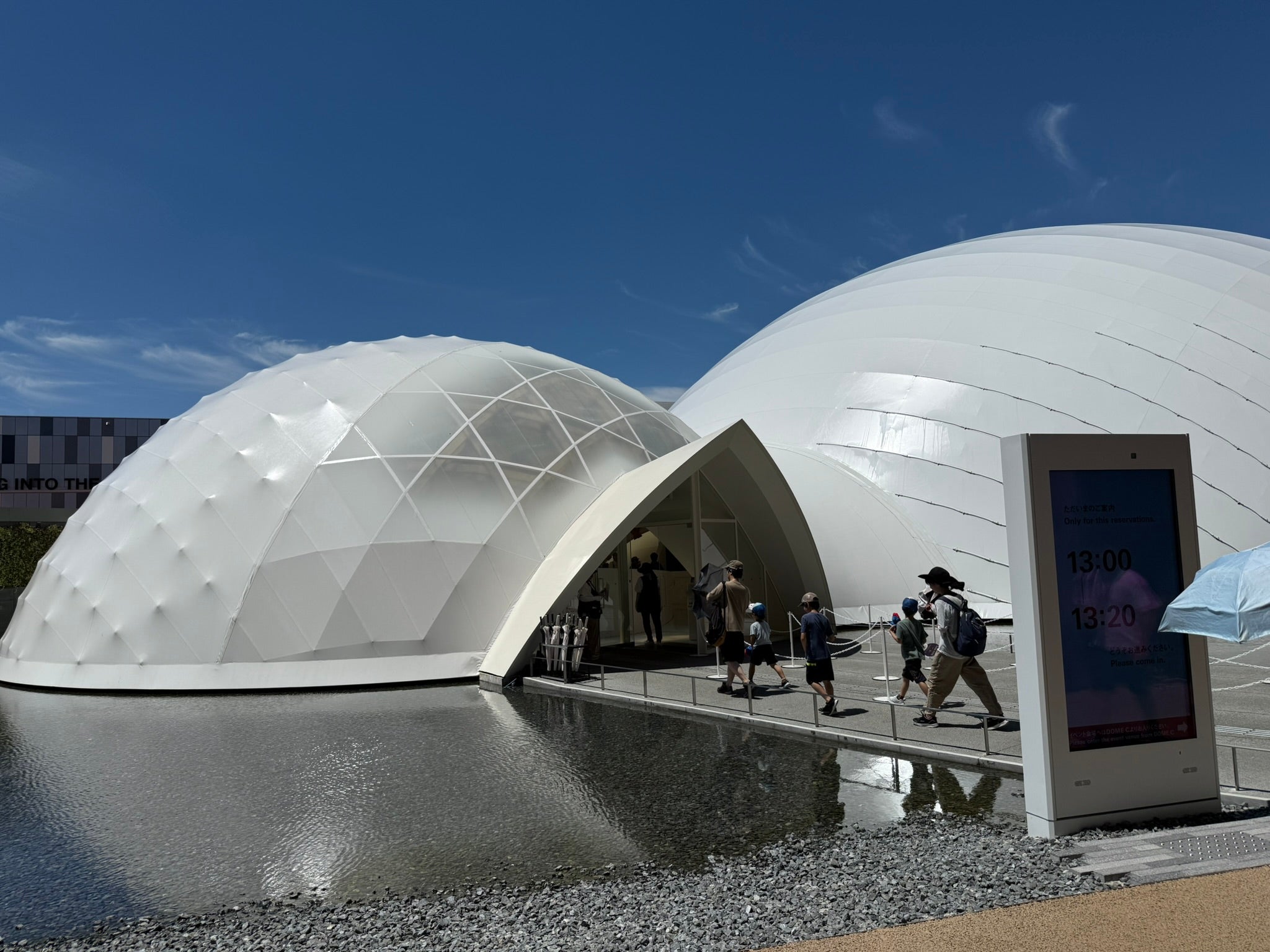 Photo from the World Expo 2025 in Osaka showing the exterior of two furiristic orb-like buildings and a bridge to them