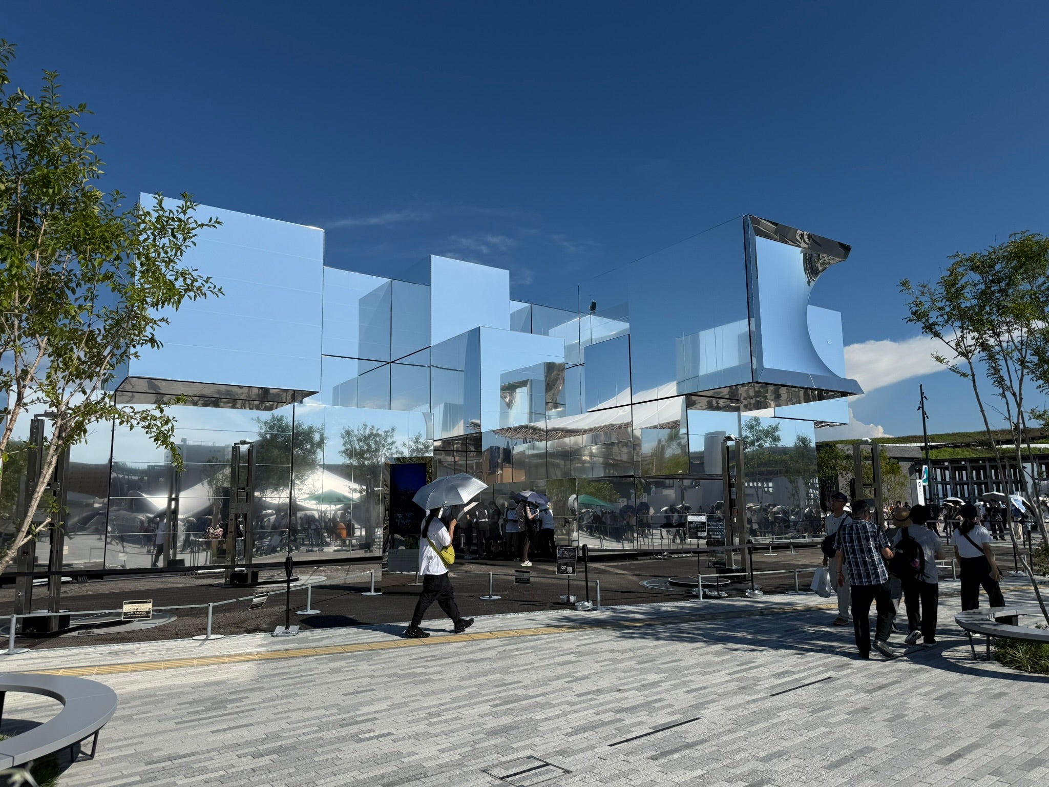 Photo from the World Expo 2025 in Osaka showing exterior of a futiristic, cubist, mirrored structure