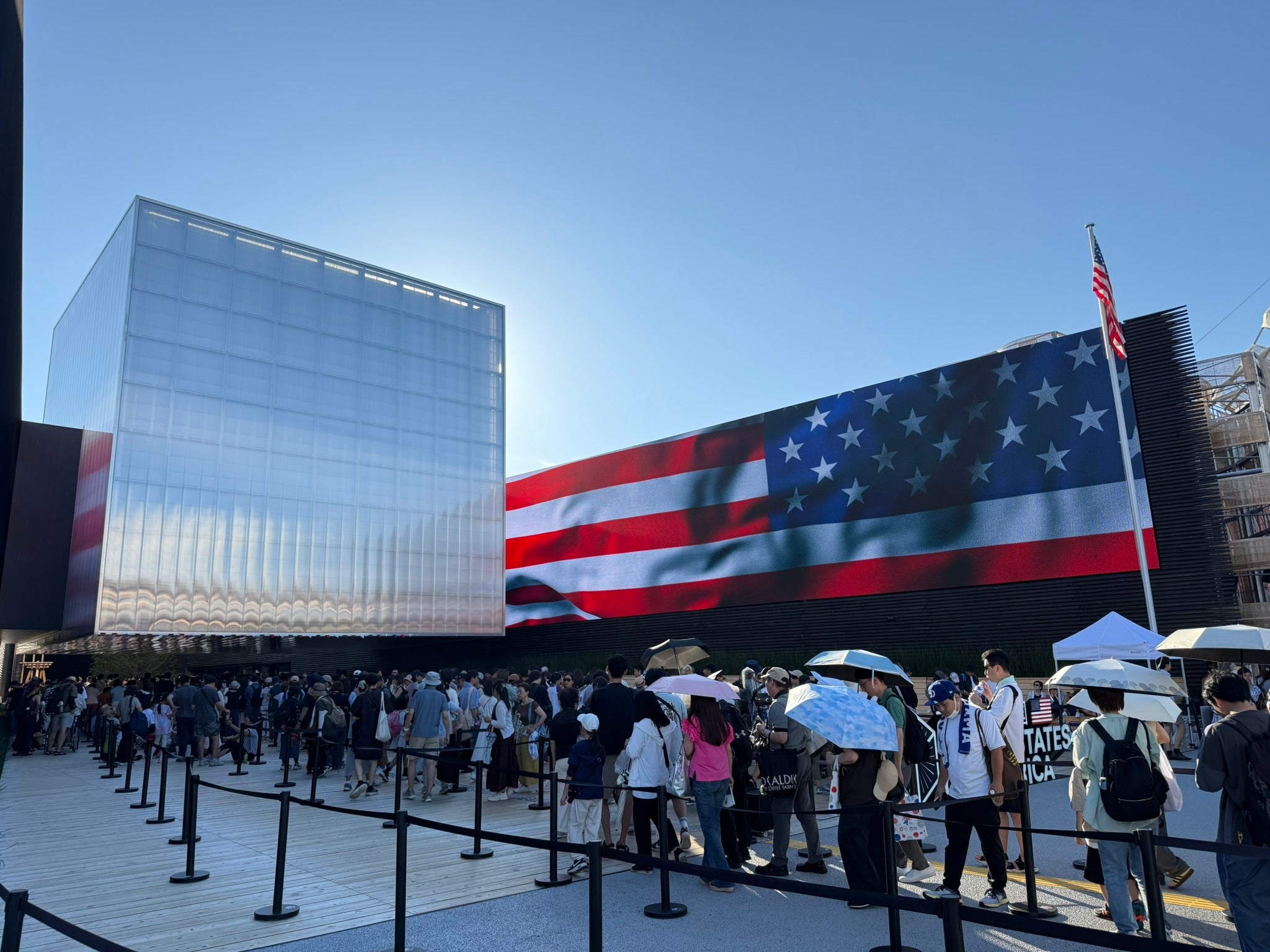 Osaka 2025 worlds fair photo showing the exterior of the US pavilion, a large ominous metal cube with giant US flag.