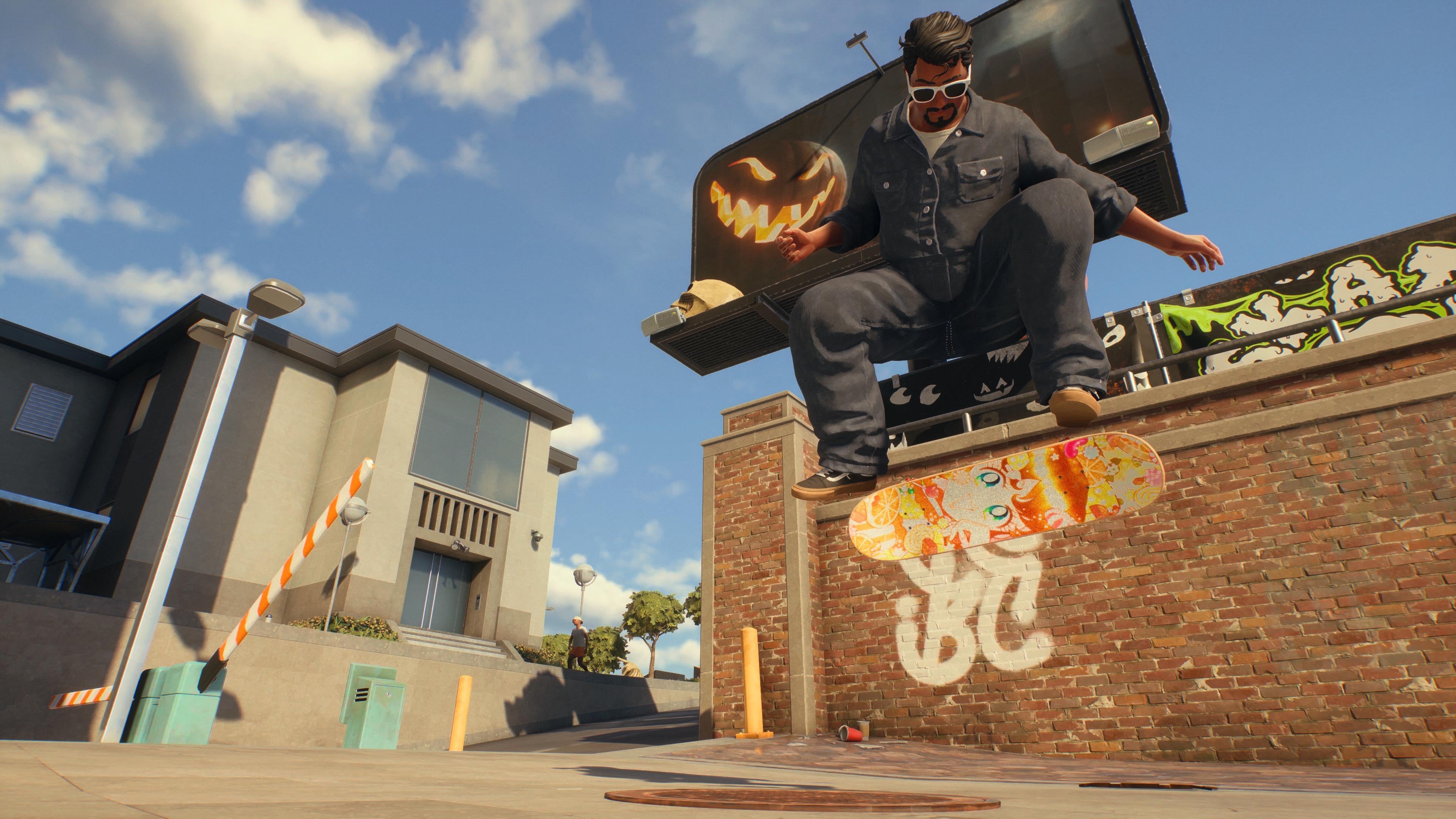 A Skate. player doing a jump with a brick wall and buildings behind under a blue sky.