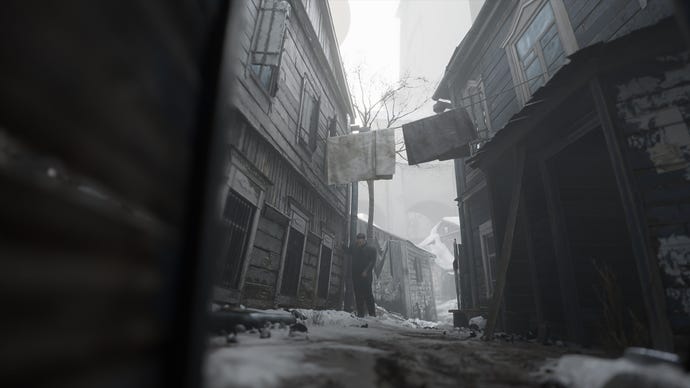 A gloomy 19th century street with laundry hung across it in Russian adventure game Indika.