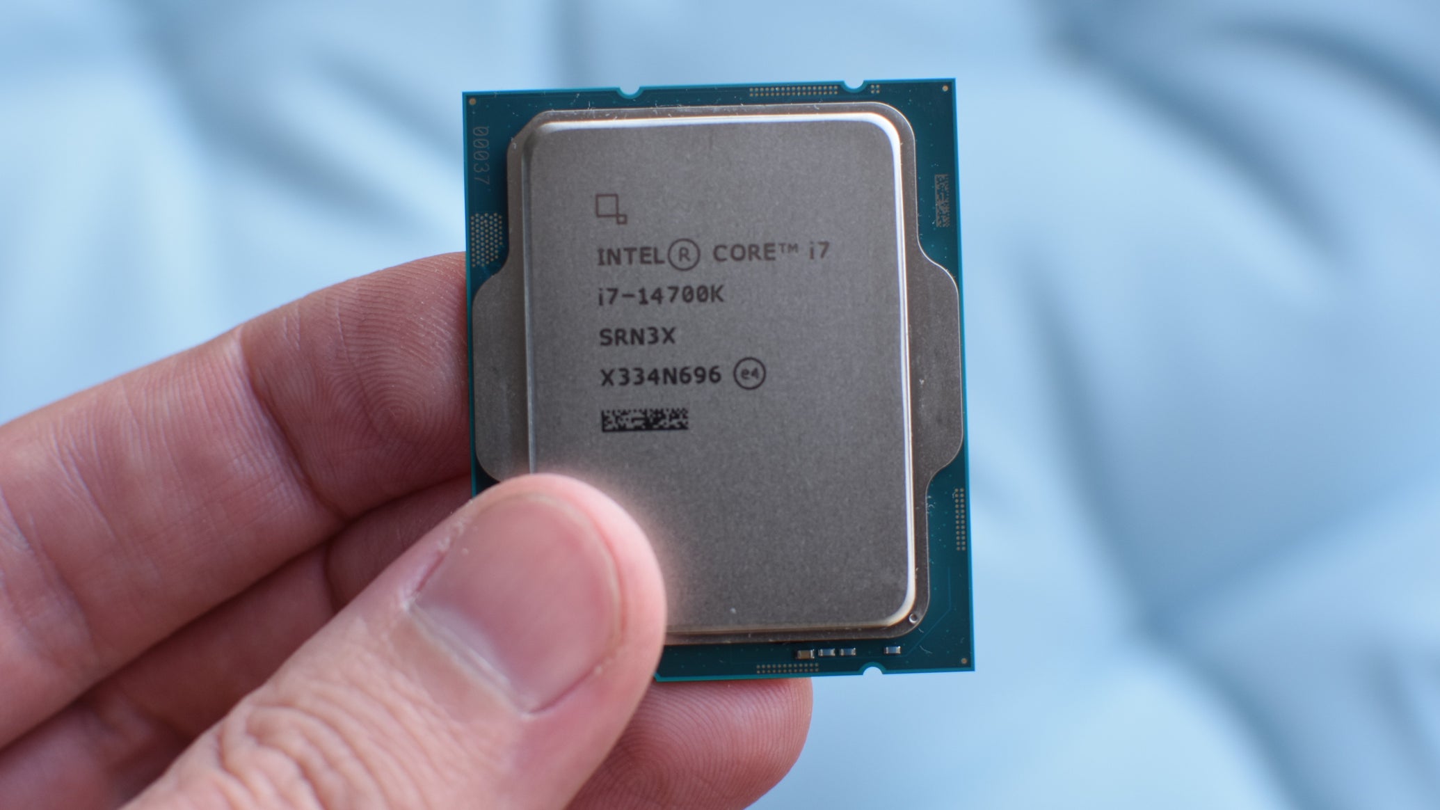 A hand holding an Intel Core i7-14700K CPU. - 1
