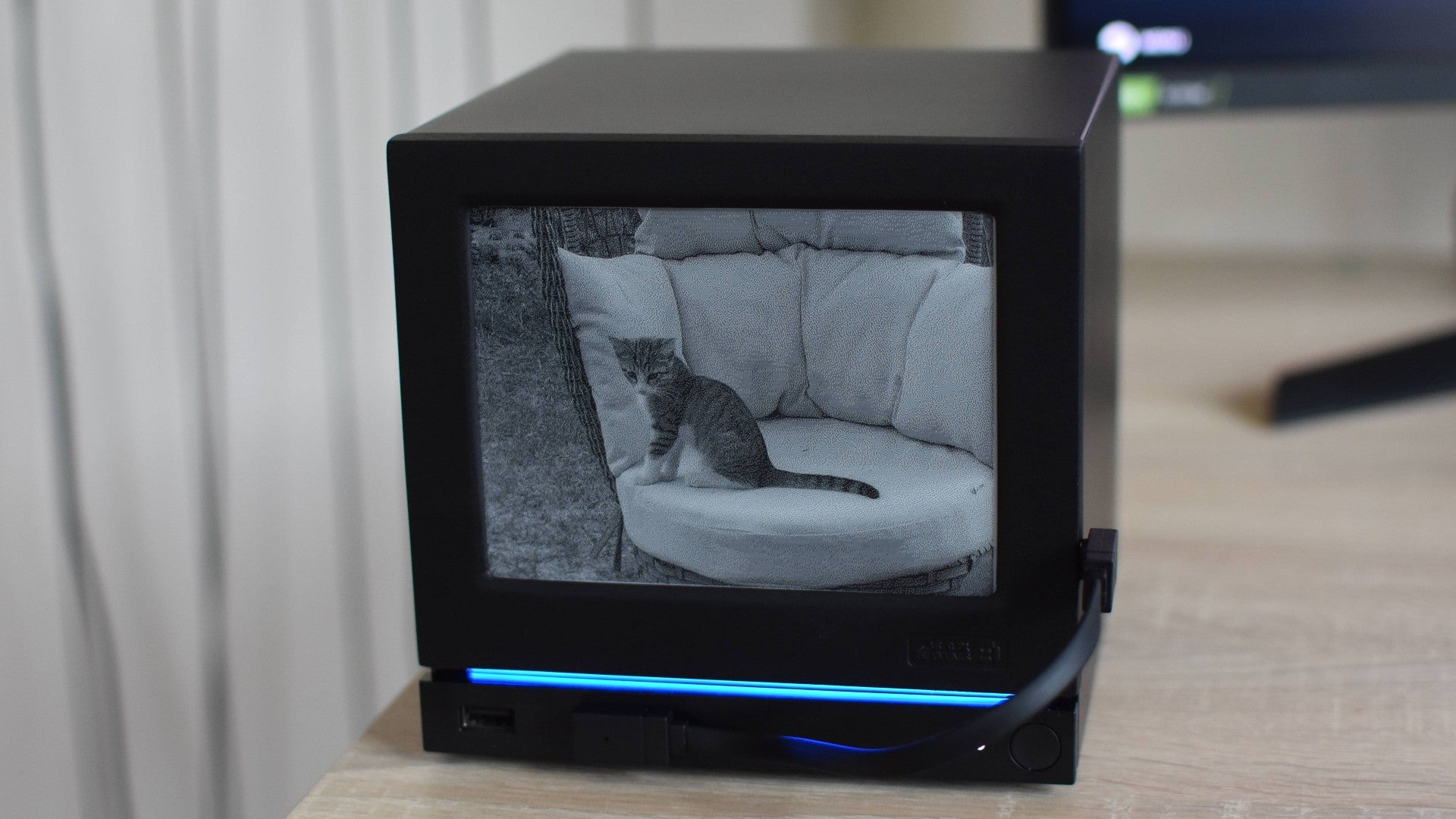 A Steam Machine equipped with a JSAUX E-Ink faceplate, showing a photo of a cat on a chair.