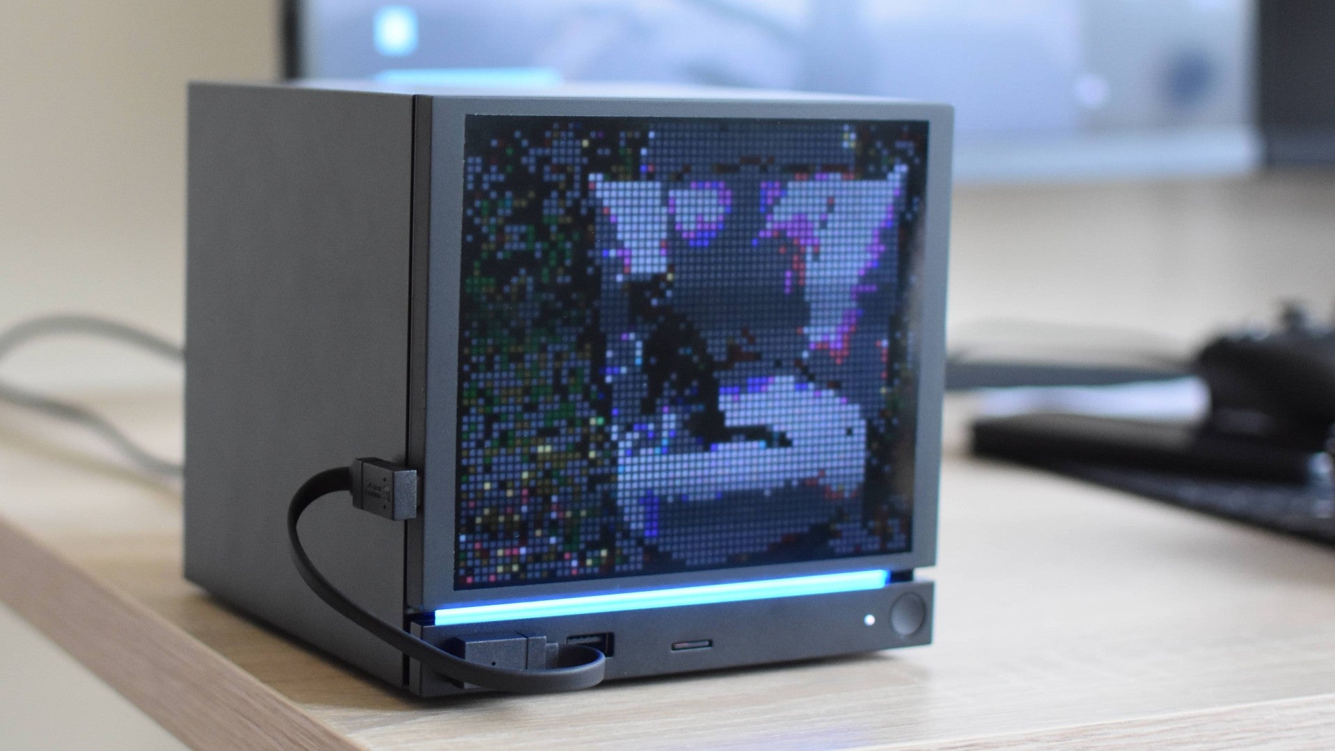 A JSAUX PixelMatrix faceplate on a Steam Machine, showing a heavily pixellated image of a cat on a chair.