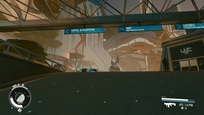 looking up at blue signs above a walking ramp showing the way to hotels and shops, the nat trams, and uc security office