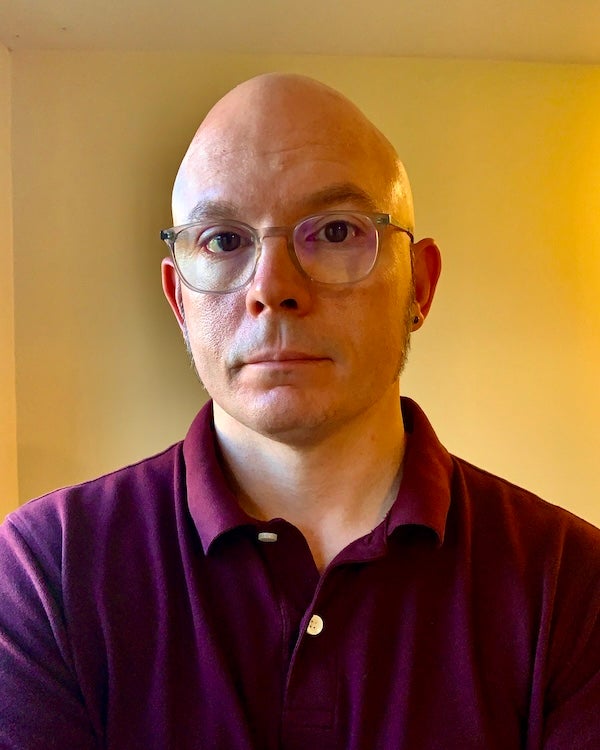 Josemonkey&rsquo;s headshot - he looks at the camera stood in front of a blank background.