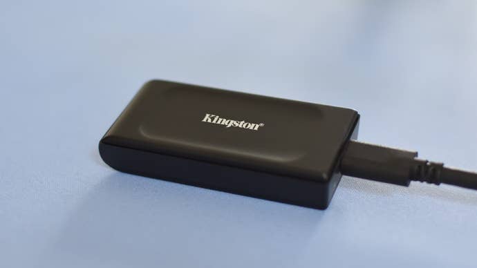 The Kingston XS1000 SSD on a blue mat.