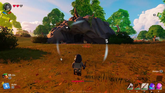 The player stands in front of a cave entrance in LEGO Fortnite