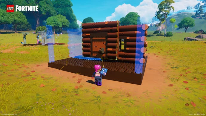 Lego Fortnite screenshot showing a log cabin being built, wall by wall.