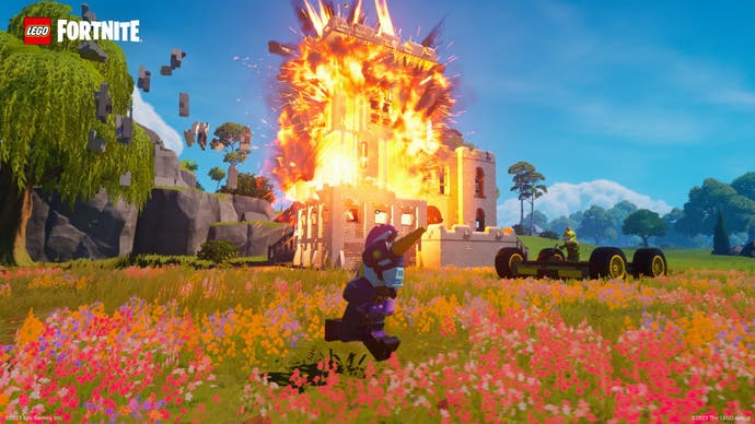 Lego Fortnite screenshot showing a building exploding, bricks flying outwards.