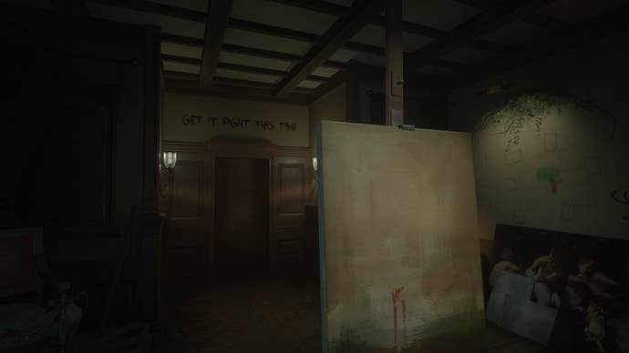 The player looks at a canvas, with some text on the wall visible behind it, in Layers of Fear (2023)