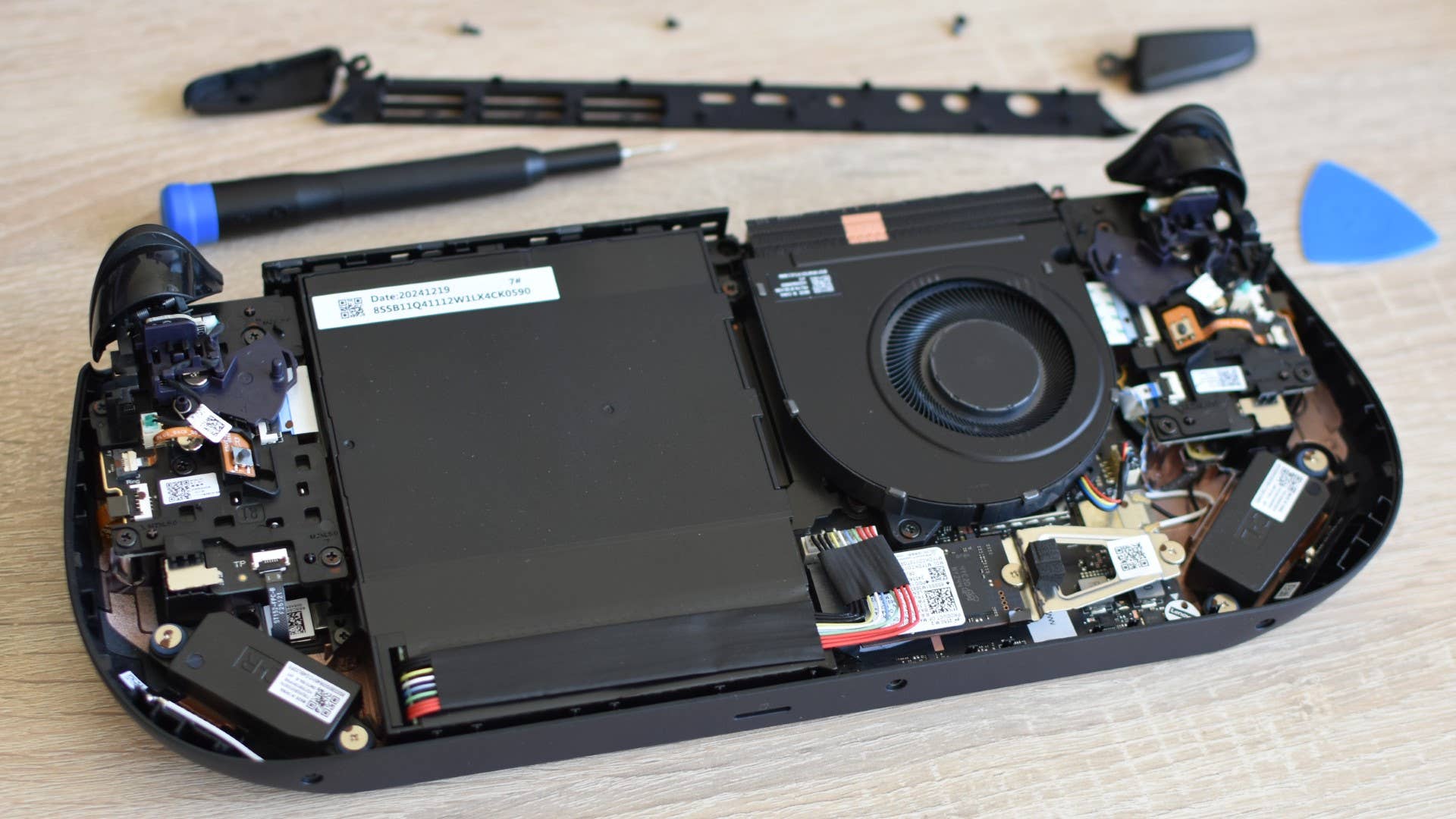 The Lenovo Legion shows the inside of the handheld PC and the SSD with the rear casing removed.